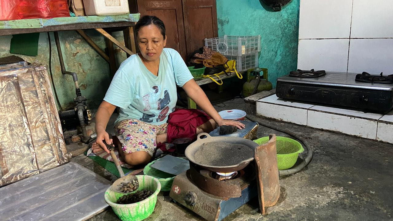 Ida Kristiani (49), penumbuk emping dari salah satu pengepul di Kampung Emping Belinjo, melakukan aktivitas produksi di rumahnya di Koplakan, Kecamatan Pare, Kabupaten Kediri, Kamis (8/10/2026). Selama 35 tahun, dia bekerja untuk pasangan (alm.) Mansyur dan Siti Munawaroh, generasi kedua di kampung itu, yang kini usahanya diteruskan oleh anak mereka, Mukti Akbar (31). Semua proses ia lakukan di rumah tanpa harus meninggalkan perannya sebagai istri dan ibu dari dua orang anak. (Foto: Yanuar Dedy/jatimnow.com)