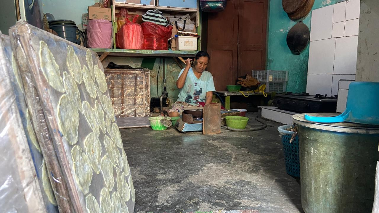 Ida Kristiani (49) menumbuk biji melinjo yang telah disangrai hingga menjadi kepingan tipis di rumahnya di Koplakan, Kecamatan Pare, Kabupaten Kediri, Kamis (8/10/2026). Proses pemipihan membutuhkan ketepatan dan keterampilan tangan agar menghasilkan bentuk emping yang sesuai. (Foto: Yanuar Dedy/jatimnow.com)