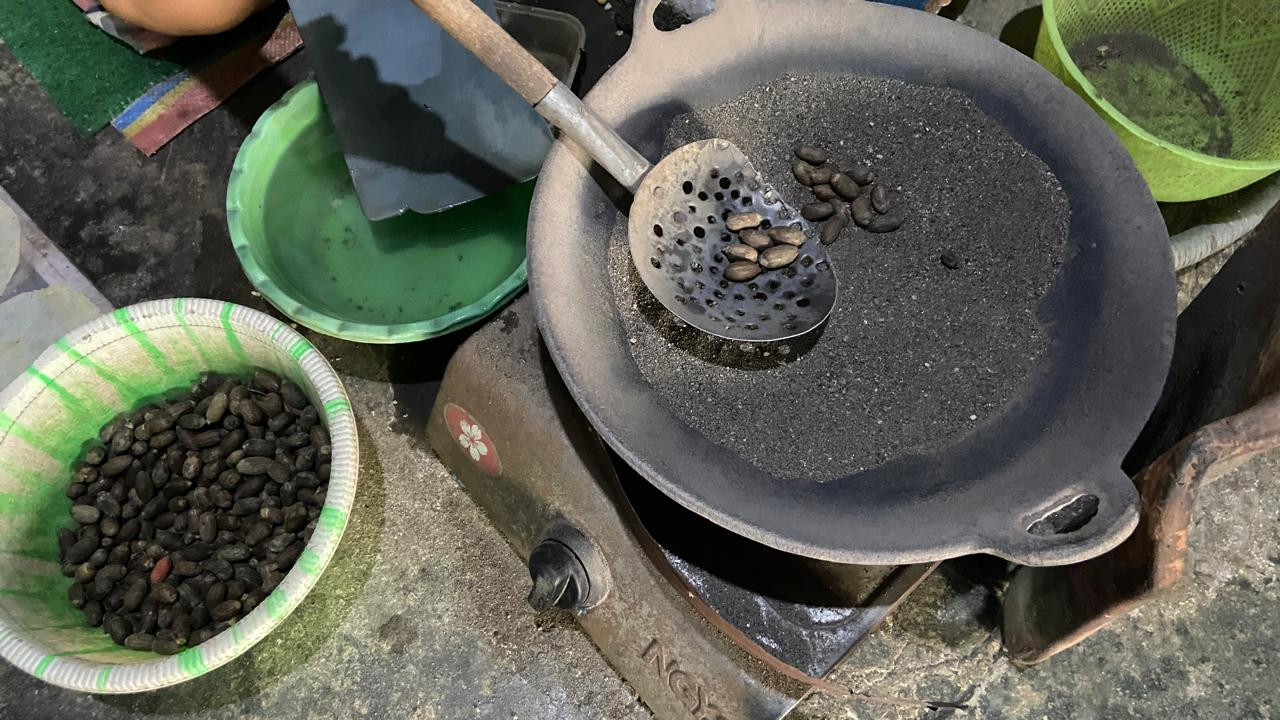 Ida Kristiani (49) menyangrai biji belinjo menggunakan pasir yang telah dipanaskan dengan LPG 3 kilogram di rumahnya di Koplakan, Kecamatan Pare, Kabupaten Kediri, Kamis (8/10/2026). Biji belinjo disangrai tanpa minyak hingga siap dipipihkan. Selain kompor gas satu tungku, peralatan yang digunakan belum berganti sejak awal Ida bekerja. (Foto: Yanuar Dedy/jatimnow.com)