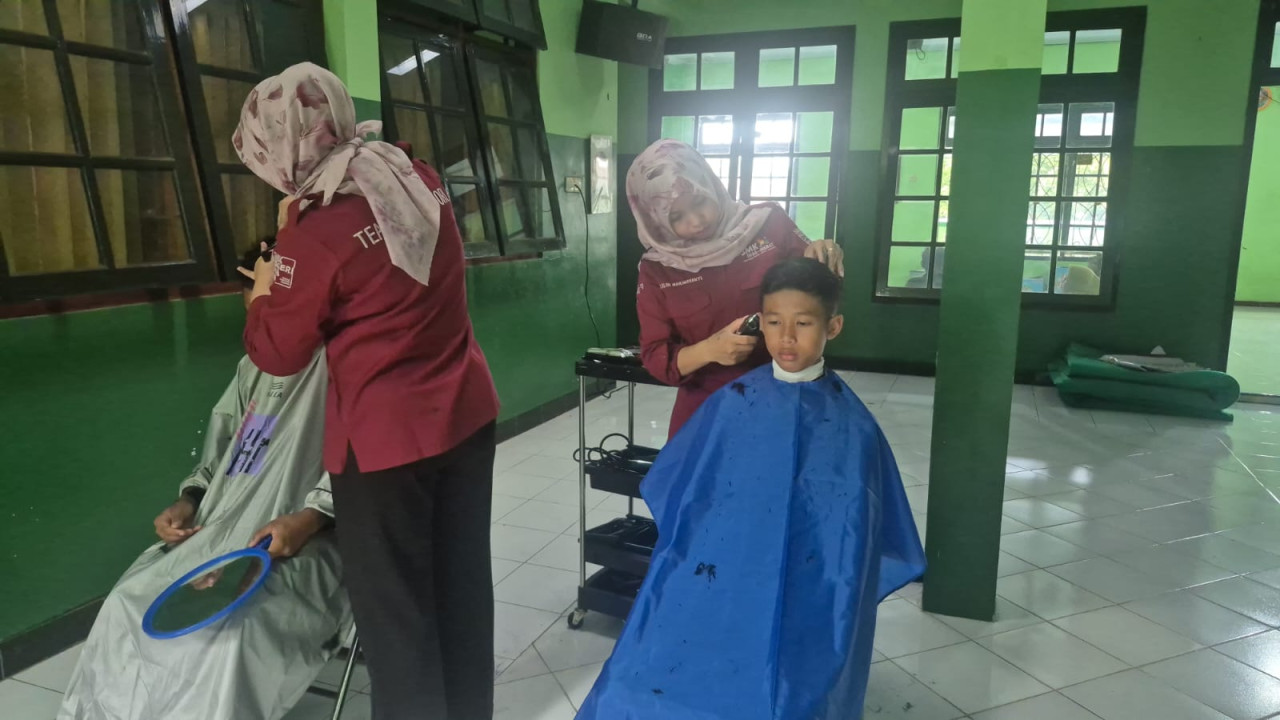 Penghuni panti asuhan Al Ikhlas saat potong rambut gratis oleh siswa SMKN 2 Ponorogo. (Foto: Ahmad Fauzani/jatimnow.com)