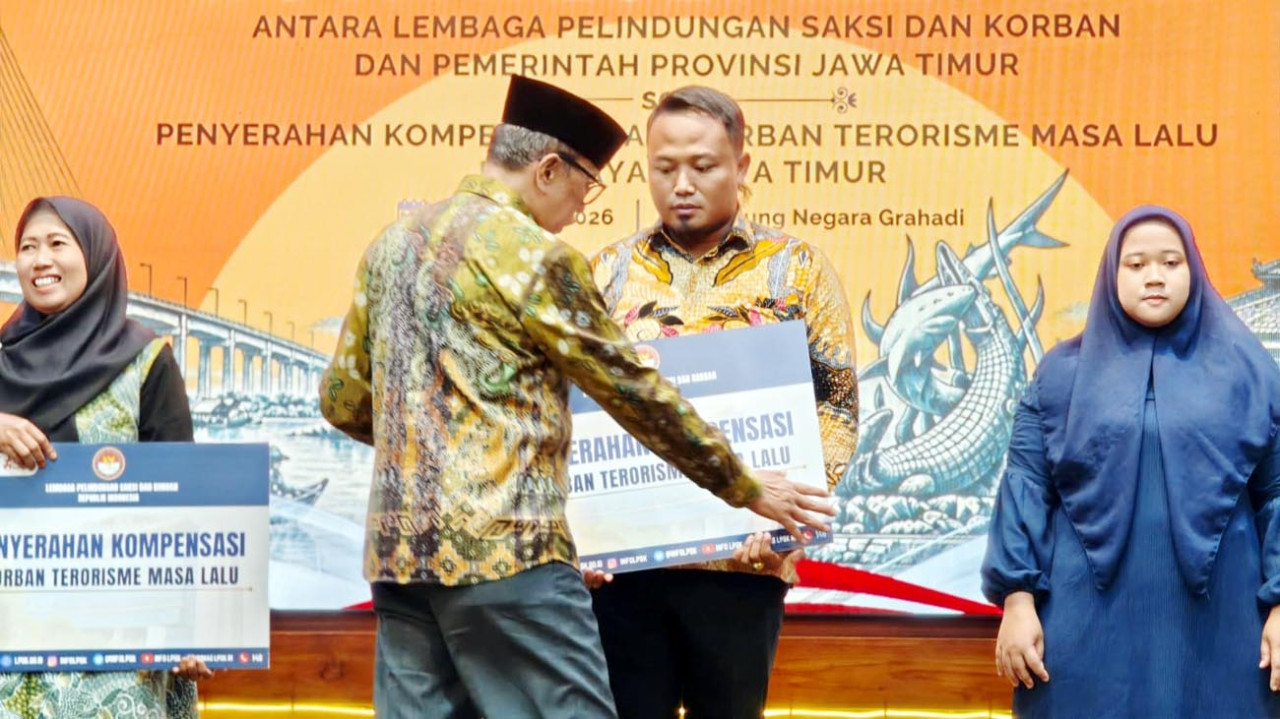 Ketua LPSK Achmadi menyerahkan kompensasi negara kepada korban bom Surabaya, di Gedung Negara Grahadi, Surabaya, Kamis (1/10/2026). (Foto: Ali Masduki/jatimnow.com)
