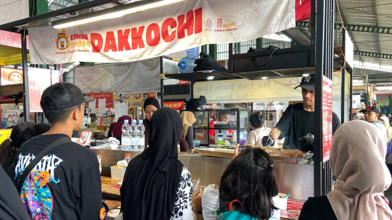 Suasana Pasar Pasar Rakyat Klojen Nikmat, pada Sabtu (24/10/2026). Sejumlah pengunjung mengantre di lapak Korean Chicken Skewers - Dakkochi. Tak hanya kuliner tradisional, jajanan kekinian juga ada di pasar ini. Antreannya dipadati Gen Z. (Foto: Yanuar Dedy/jatimnow.com)