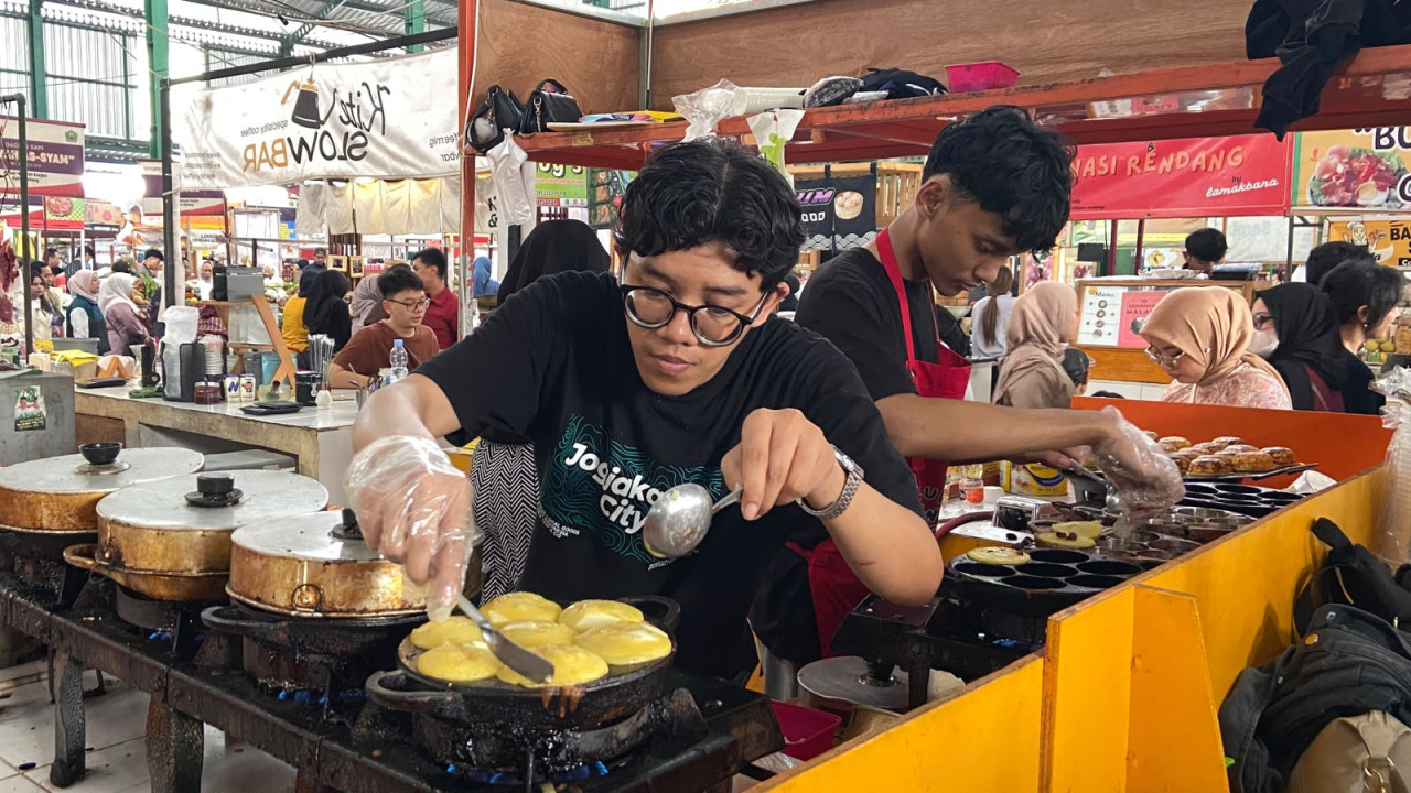 Pekerja di lapak Lumpur Kentang Panggang Klodjen tengah membuat lumpur, pada Sabtu (23/10/2026). Di akhir pekan, permintaan lumpur meningkat membuat pekerja di tiga lapak mereka harus bekerja lebih cepat. (Foto: Yanuar Dedy/jatimnow.com)