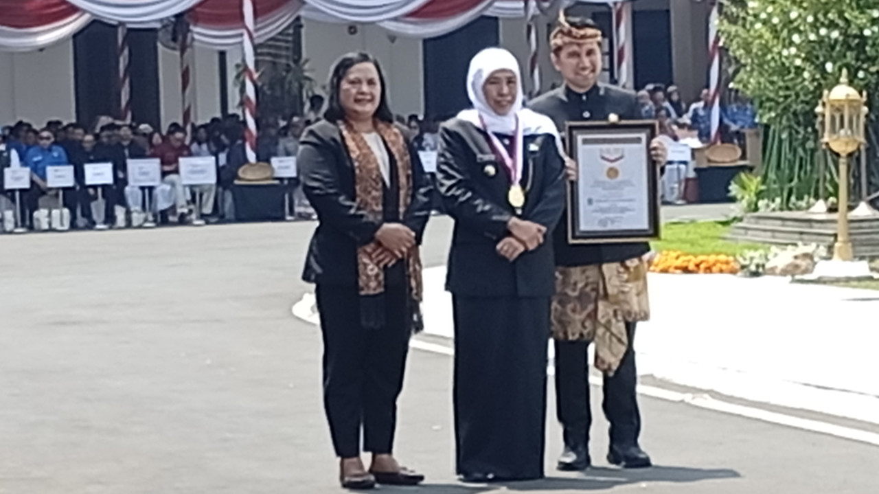 Gubernur Jawa Timur Khofifah Indar Parawansa dan wakilnya Emil Dardak menerima piagam penghargaan tersebut dari Direktur Utama MURI Aylawati Sarwono. (Foto: Sujianto/jatimnow.com)