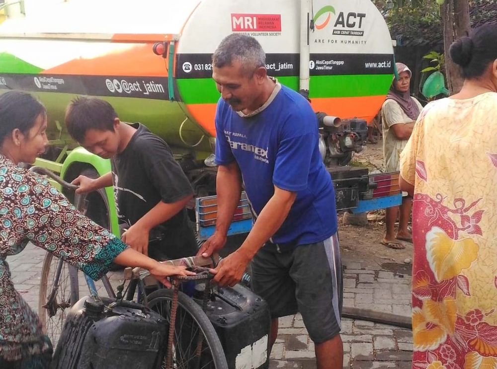 Warga terlihat ceria mendapat bantuan air bersih dari ACT Jatim