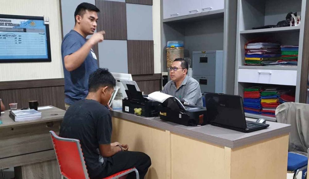 Ajis (duduk di kursi merah) di Mapolda Jatim