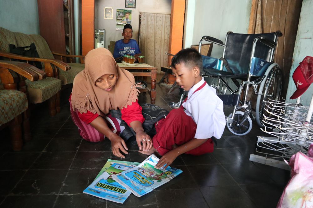 Fattan menyiapkan keperluan sekolah dibantu Tutik, ibunya