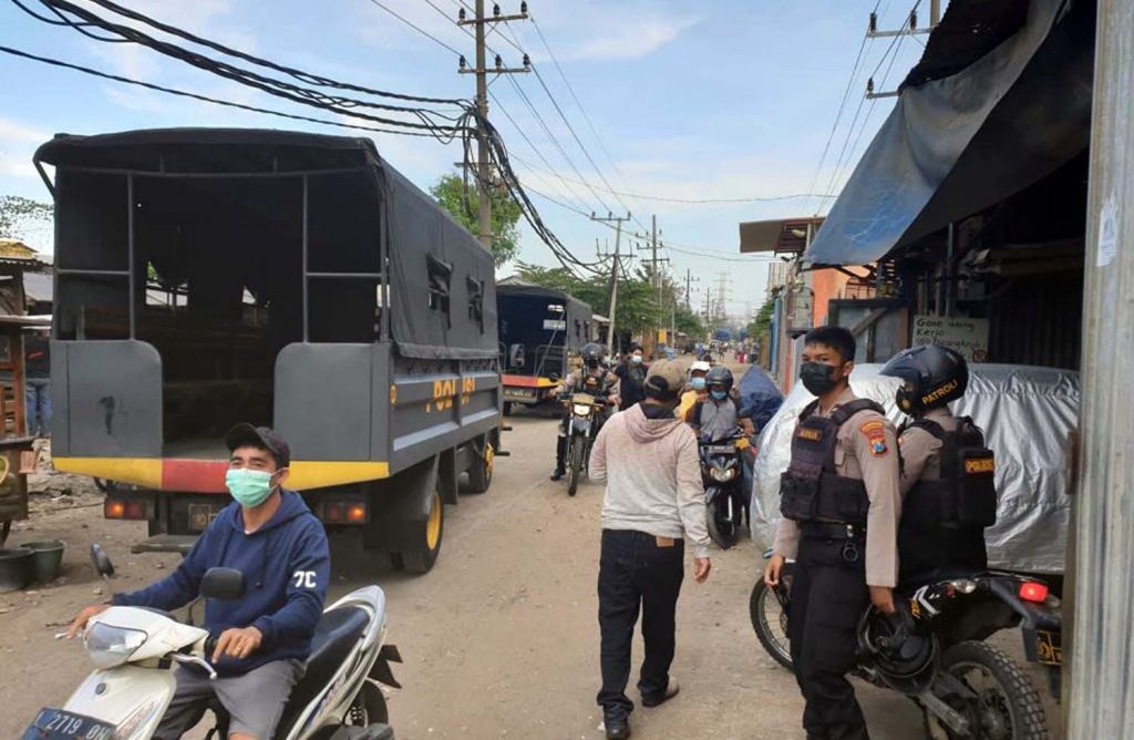 Polisi saat menggerebek arena judi burung merpati di Tambaksari, Surabaya