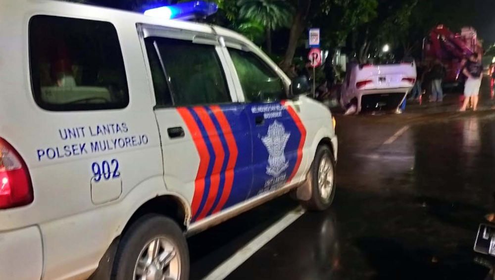 Unit Laka Satlantas Polsek Mulyorejo mengamankan TKP mobil BMW terbalik