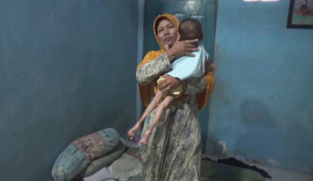 Ahmad Fajar, balita bertubuh kaku saat digendong Neneknya, Asmiatun di rumahnya di Mojokerto