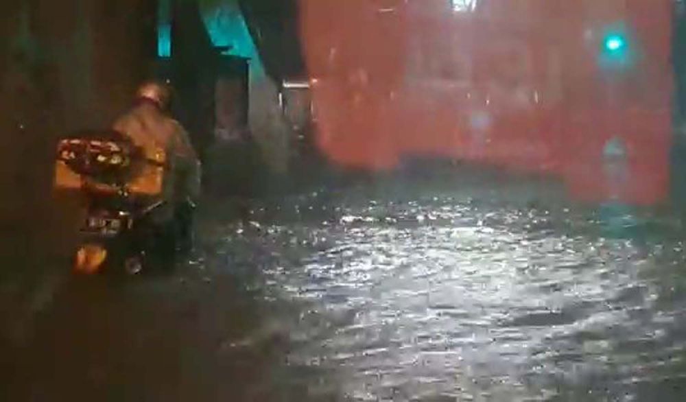 Pengendara motor melintas di Jalan Mayjen Sungkono, Surabaya yang terendam banjir