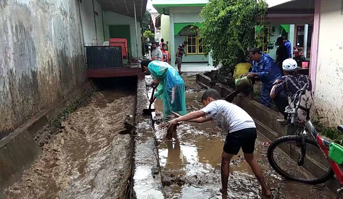 Warga membersihkan lumpur akibat banjir bandang yang merendam ke rumah mereka