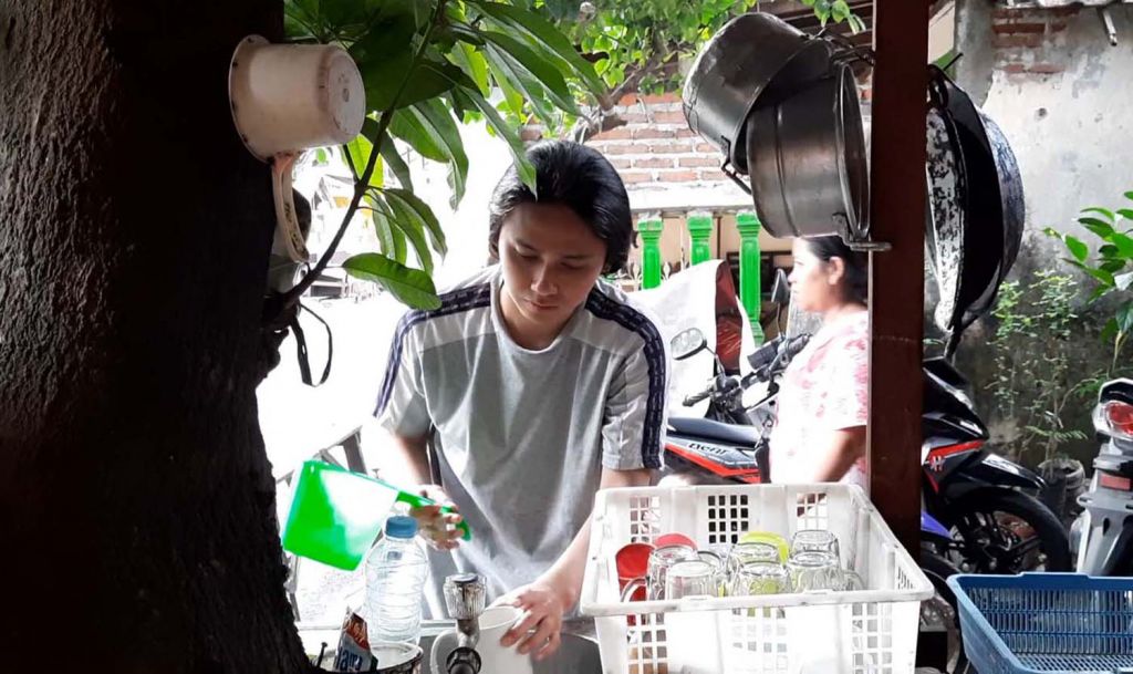 Oni saat berjualan kopi di warungnya di Surabaya (Foto: Niam Kurniawan/jatimnow.com)