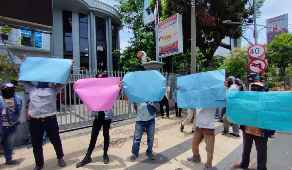 Pendemo menggelar aksi di depan Kantor Warna Warni di Jalan Panglima Sudirman, Surabaya