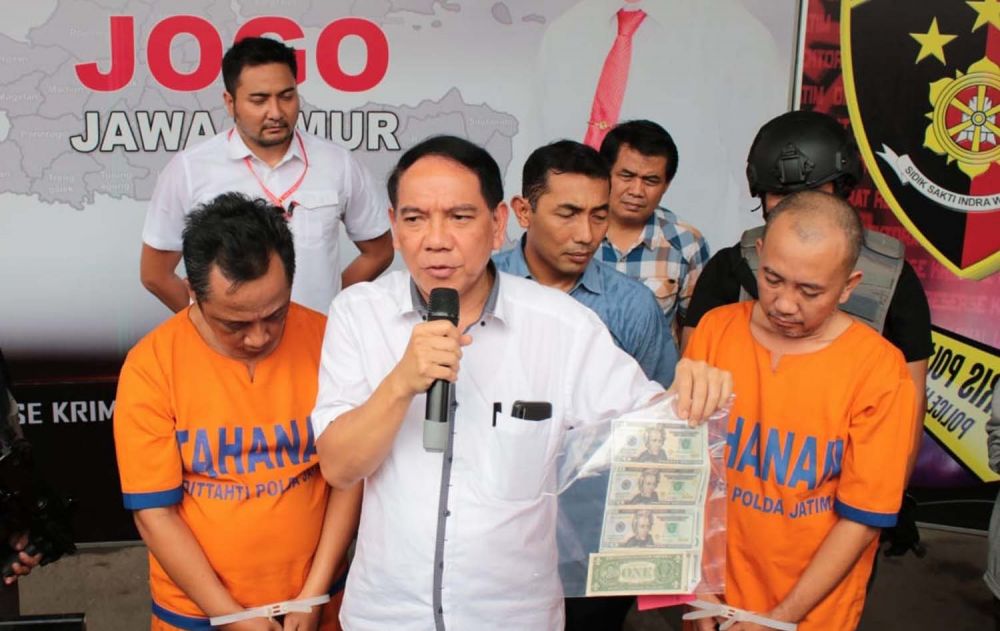 Dirreskrimum Polda Jatim Kombes Pol R Pitra Andrias Ratulangie menunjukkan dua tersangka dan uang palsu yang dibuat dan diedarkan