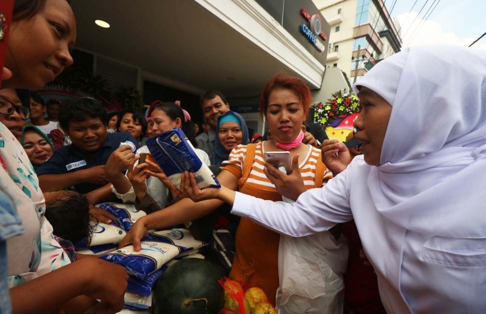 Gubernur Khofifah saat memberikan gula gratis untuk ratusan warga di pasar buah dan gula murah Jalan Jimerto 17A, Surabaya 
