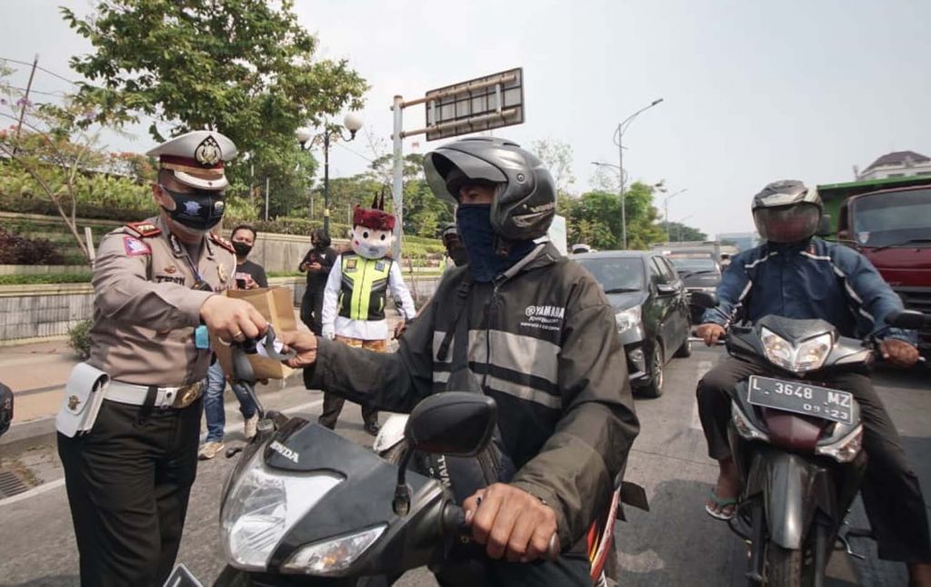 Kasatlantas Polrestabes Surabaya AKBP Teddy Chandra membagikan masker ke pengguna jalan