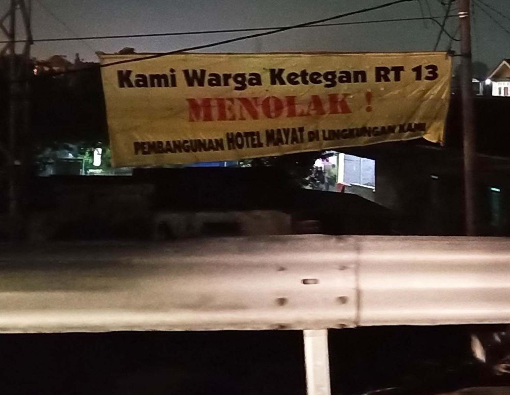 Spanduk penolakan pembangunan Hotel Mayat terlihat dari jalan tol