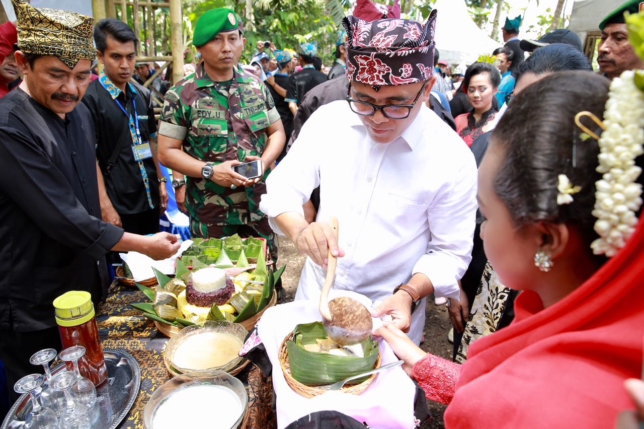 Bupati Anas menyajikan makanan dalam festival durian di Kampung Durian.