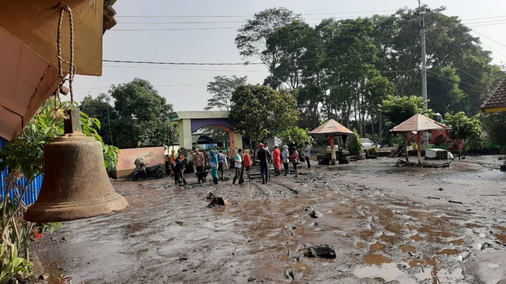 Warga di perkampungan lereng Gunung Ijen dan petugas gabungan membersihkan material lumpur