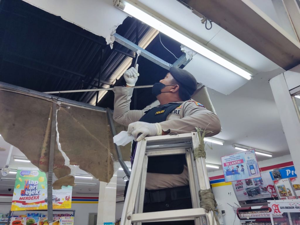 Polisi melakukan olah TKP di minimarket Indomaret.