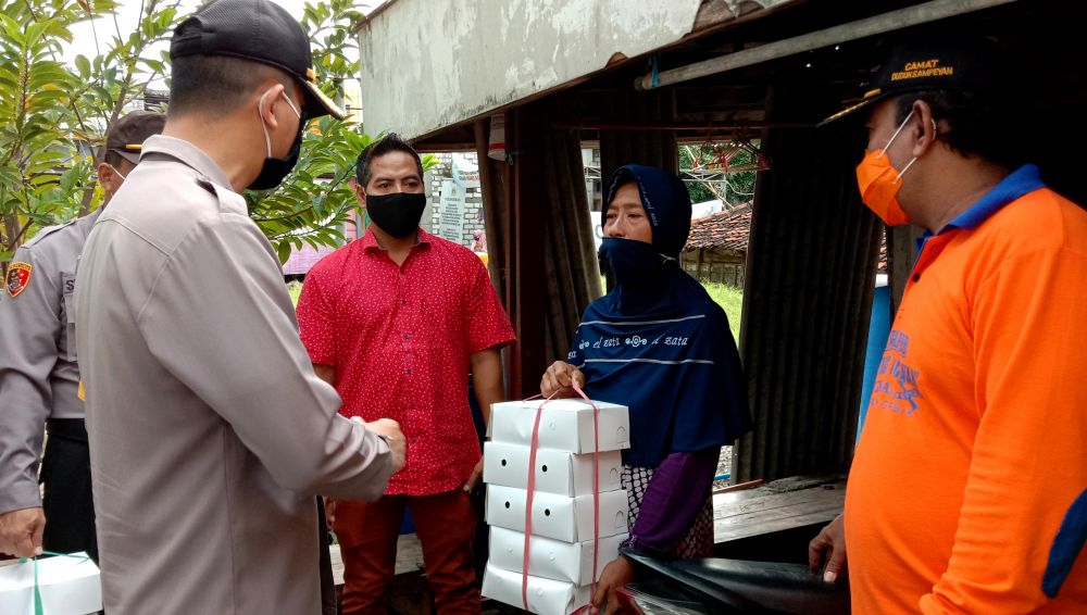 Kapolres Gresik AKBP Kusworo Wibowo memberikan nasi kotak hasil dapur umum PSBB untuk warga terdampak Covid-19