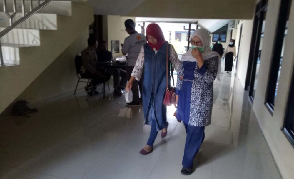 Fatimah (pakai masker) saat tiba di Mapolres Mojokerto Kota untuk diperiksa Penyidik KPK