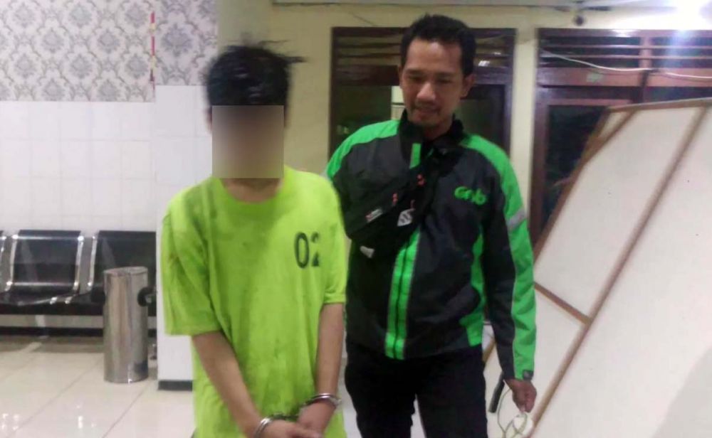 Anggota Unit Reskrim Polsek Genteng menggiring salah satu jambret yang sempat bersembunyi di sungai setelah tumbang bersama motornya di Jalan Undaan Wetan, Surabaya