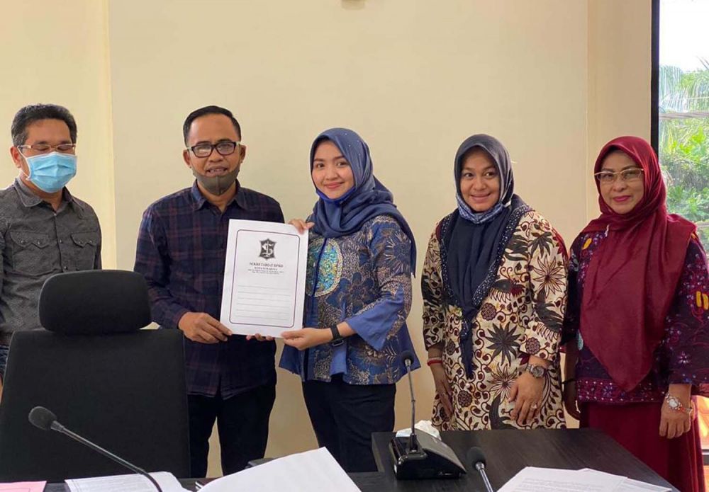 Jeje (batik biru) menyerahkan laporan ke Ketua BK DPRD Surabaya Badrut Tamam