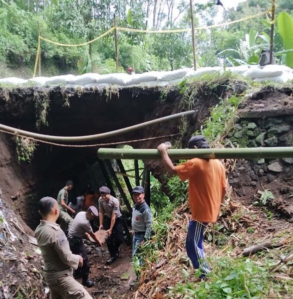 Tim gabungan memasang penyangga dari bambu serta karung berisi pasir agar jembatan yang ambrol tidak meluas
