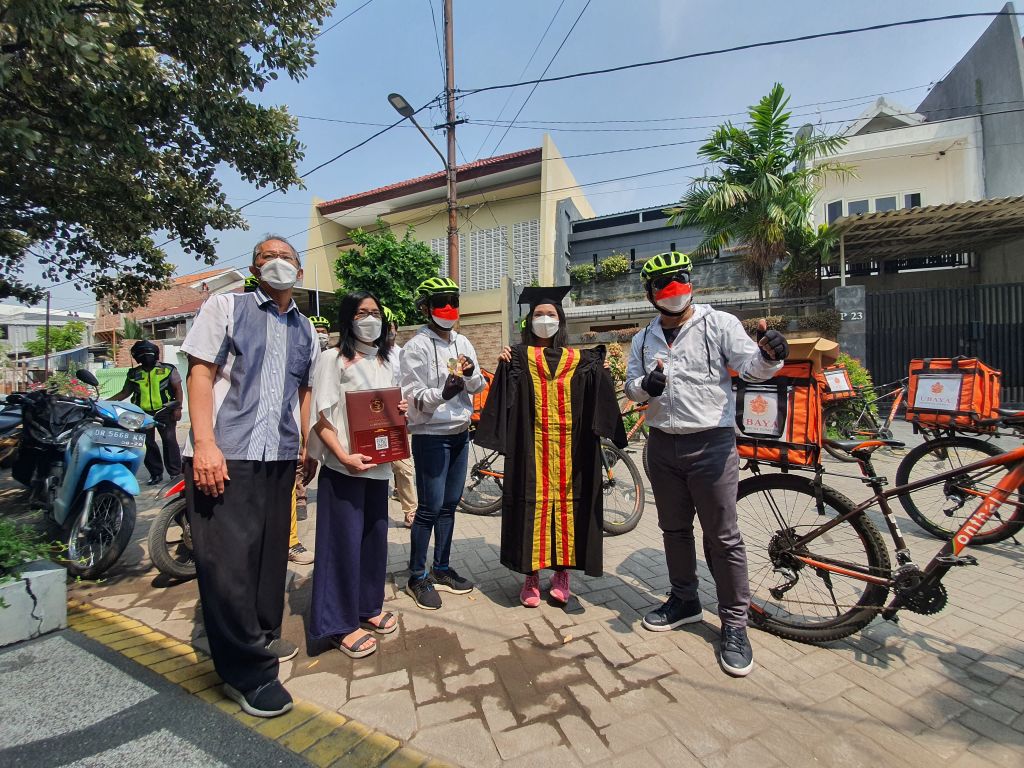 Rektor Ubaya, Benny Lianto gowes untuk mengirimkan toga ke rumah wisudawan terbaik