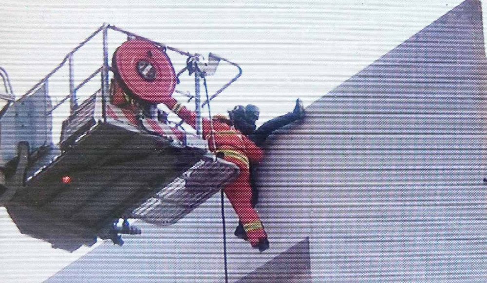 Petugas mengevakuasi korban yang terjebak di bagian atas gudang yang terbakar