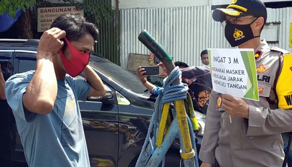 Wakapolres Pelabuhan Tanjung Perak Kompol Anggi Saputra Ibrahim membagikan masker untuk warga di Surabaya
