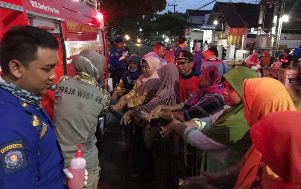 Mobil pemadam blusukan ke pasar di Trenggalek untuk mengajak warga pasar hidup sehat dengan rajin cuci tangan