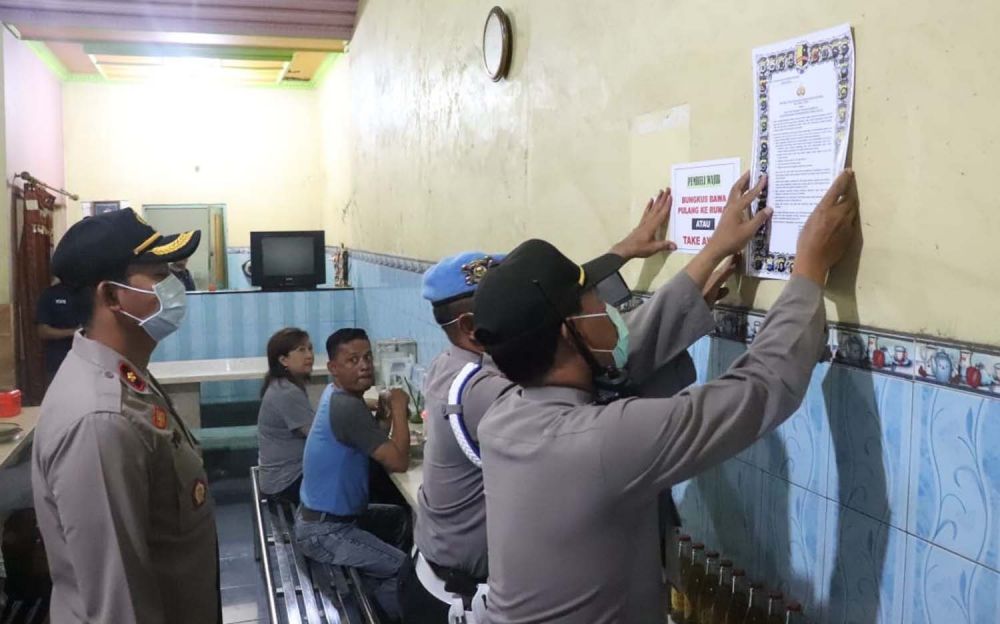 Petugas menempelkan imbauan terkait pencegahan penyebaran Virus Corona di sejumlah warung di Tulungagung