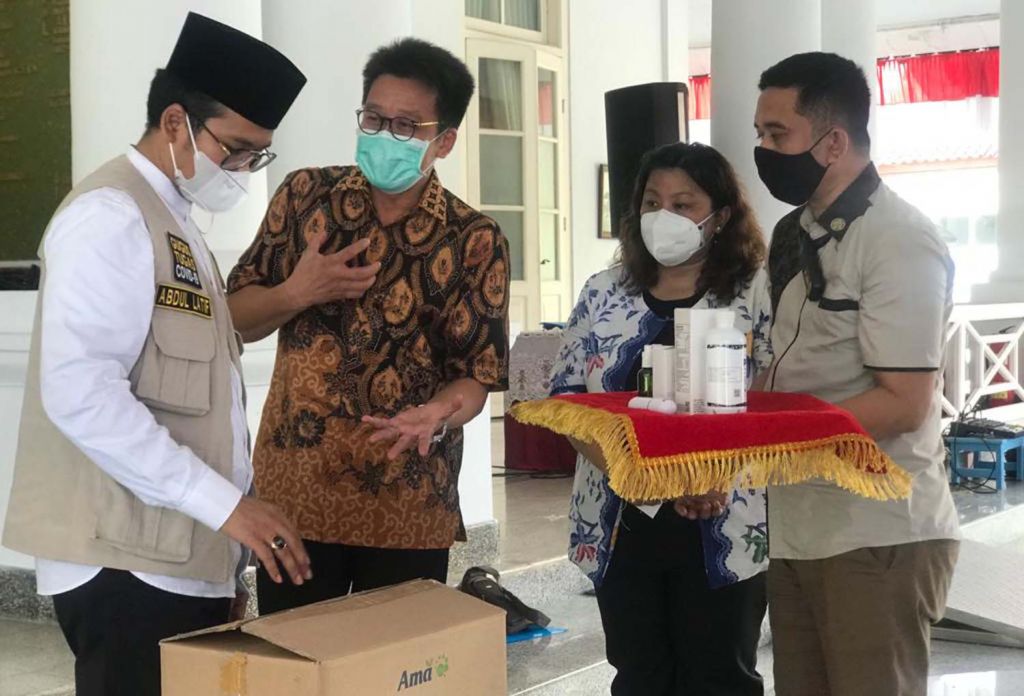 Direktur PT AMA, Recta Geson menyerahkan bantuan Pro EM1 kepada Bupati Bangkalan, Abdul Latif Imron Amin