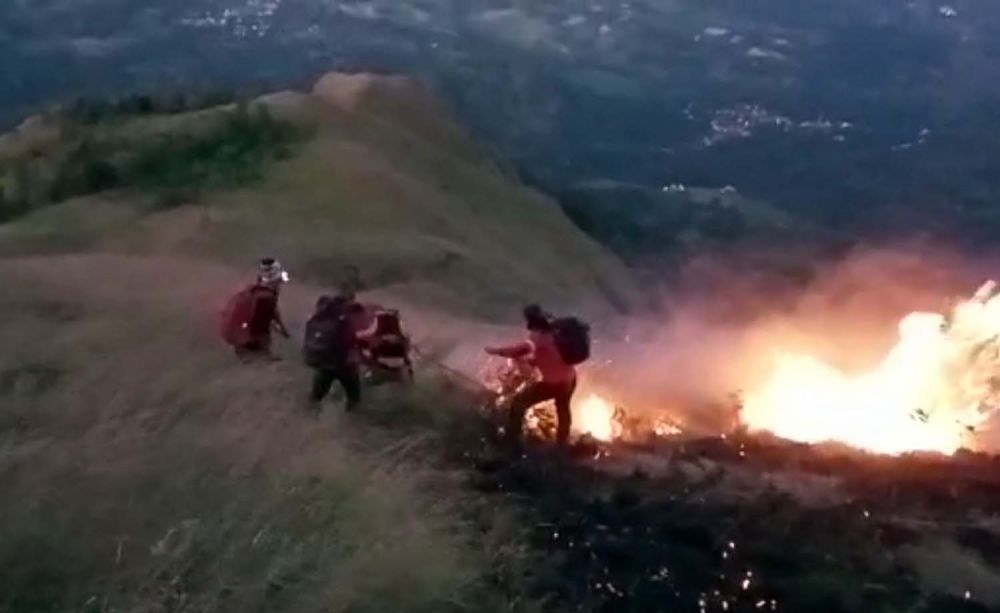 Petugas gabungan berusaha memadamkan api yang membakar 5 hektar padang savana di Gunung Penanggungan