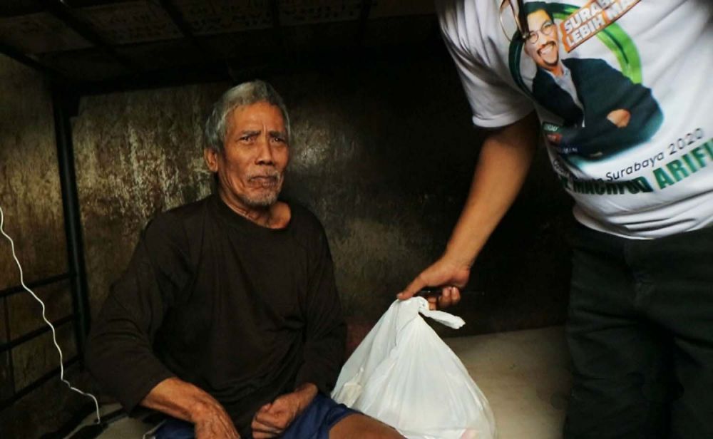 Solikin, salah satu warga RT 02 RW 02 Gubeng Airlangga Gang II saat menerima bantuan paket sembako dari Cawali Surabaya Machfud Arifin