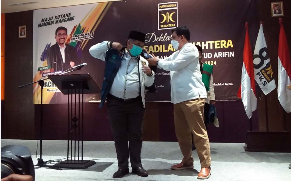 Machfud Arifin memasangkan rompi tim pemenangan ke Ketua DPW PKS Jatim Irwan Setiawan