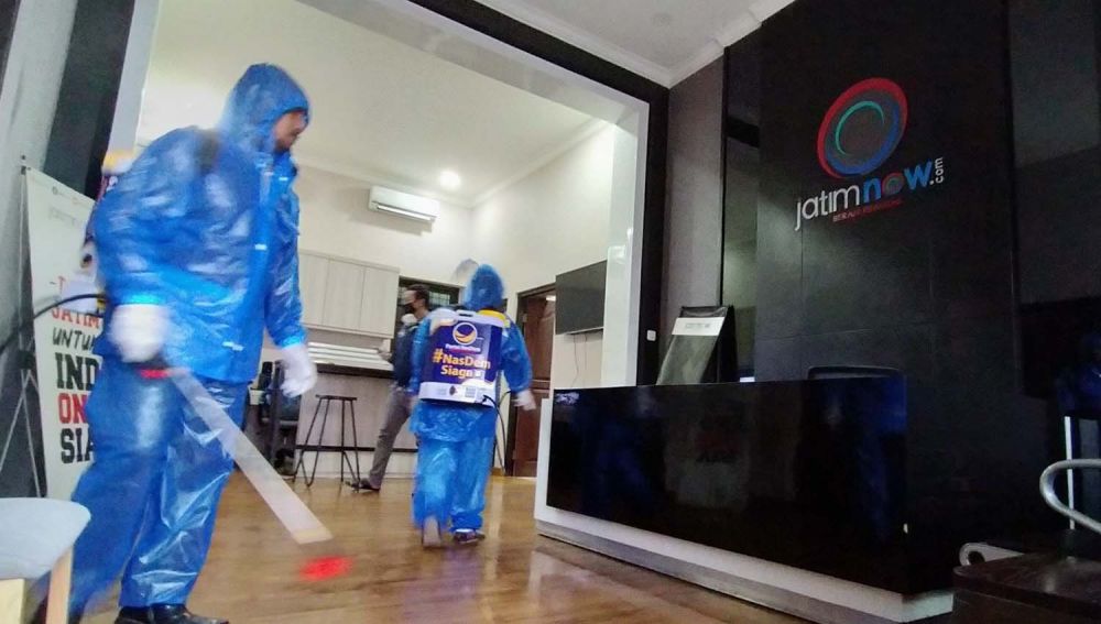 Petugas dari Partai NasDem Jatim semprotkan disinfektan di Kantor jatimnow.com Jalan Jimerto 17A, Surabaya
