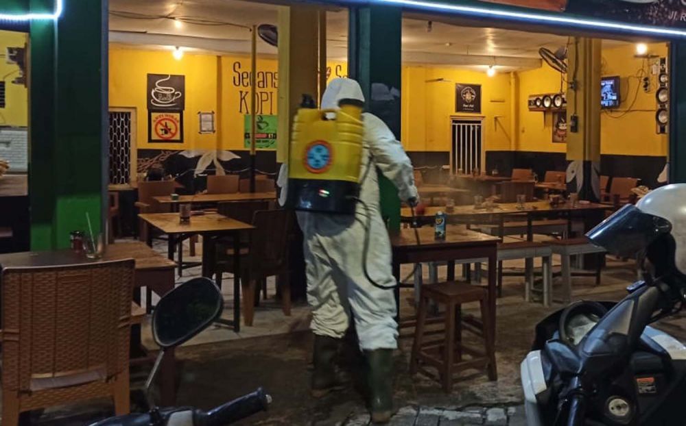 Warkop di Surabaya yang dipakai nongkrong sejumlah pengunjung disemprot disinfektan