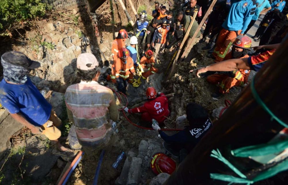 Petugas mengevakuasi dua pekerja proyek box culvert yang tertimbun dinding saluran air di Surabaya