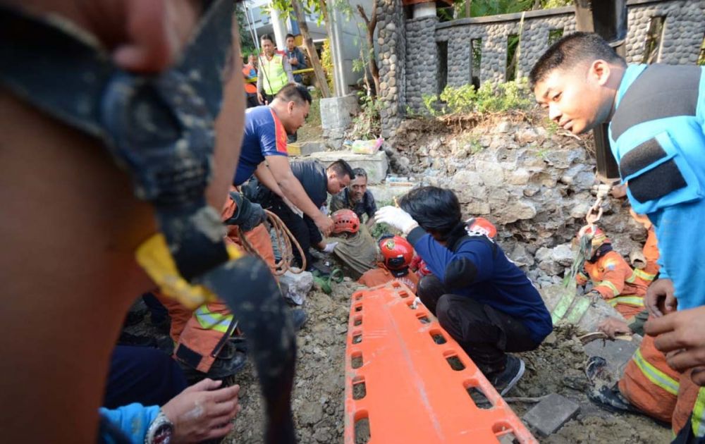 Petugas mengevakuasi dua pekerja proyek box culvert yang tertimbun dinding saluran air di Surabaya