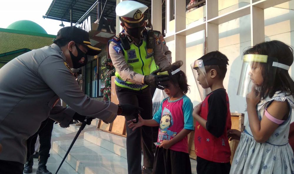 Kapolres Mojokerto AKBP Dony Alexander membagikan face shield gratis untuk anak-anak di wilayah Pacet