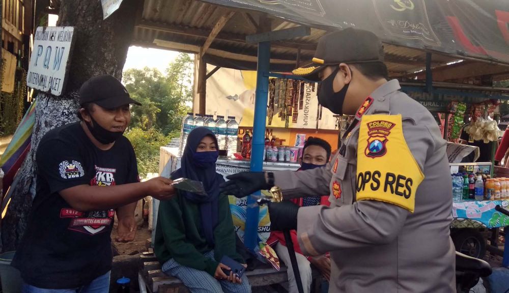 Kapolres Mojokerto AKBP Dony Alexander membagikan masker gratis untuk para pengunjung wisata Pacet