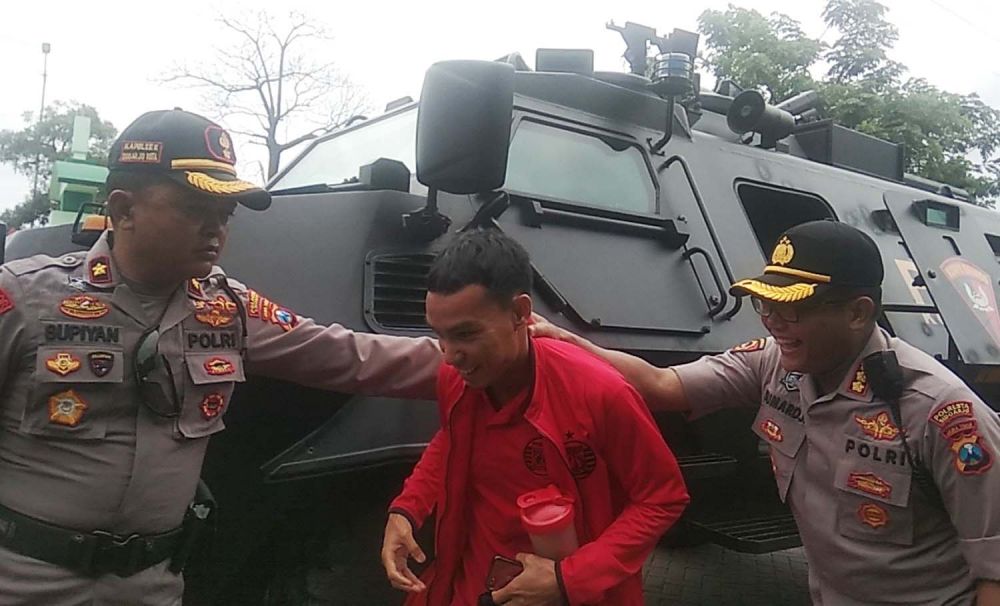 Kapolresta Sidoarjo Kombes Pol Sumardji (kanan) bercanda dengan salah satu pemain Persija yang turun dari kendaraan rantis di Stadion Gelora Delta Sidoarjo