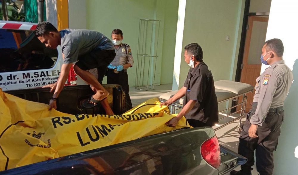 Sejumlah polisi mengevakuasi jasad korban ke rumah sakit di Probolinggo