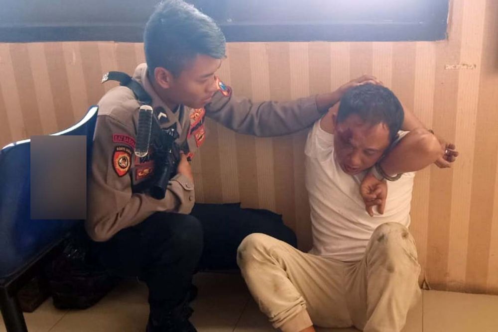 R (tangan diborgol), salah satu pembobol ATM di Kota Probolinggo