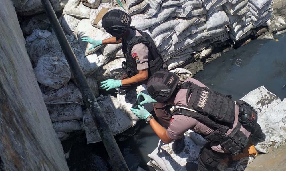 Tim Gegana Satbrimob Polda Jatim mengevakuasi benda diduga granat yang ditemukan di sungai Simokerto, Surabaya