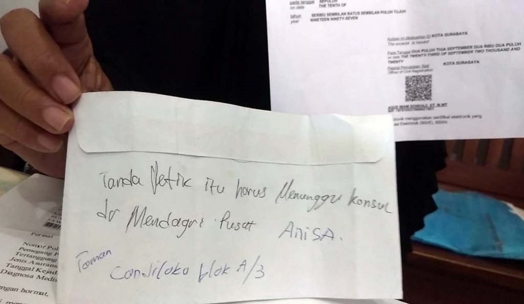 Yaidah menunjukkan tulisan tangan petugas Dispendukcapil Surabaya
